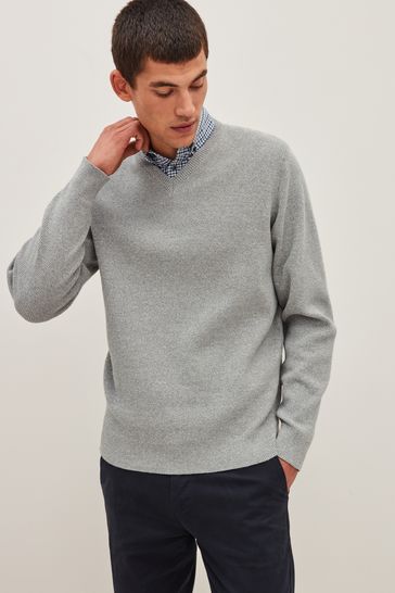 Suéter gris claro con cuello de pico y camisa simulada de cuadros