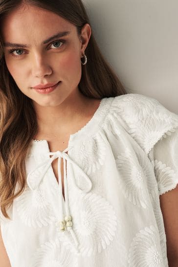 Blusa blanca de girasol de doble manga con cuello anudado 