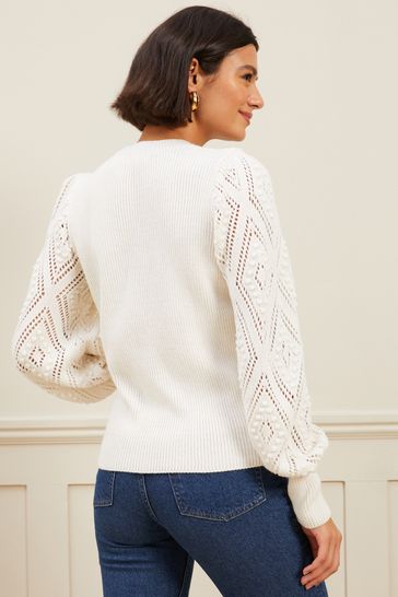 Sweater with pom pom sleeves top
