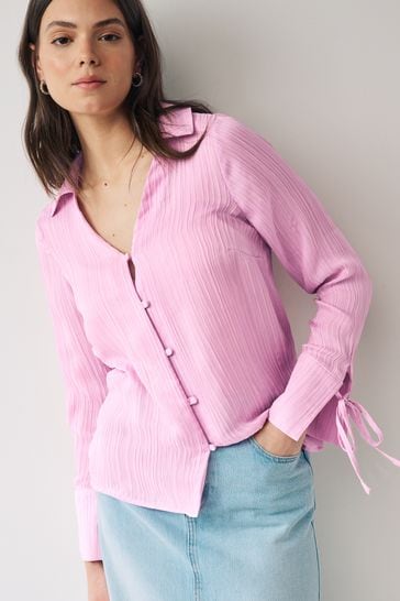 Blusa rosa con cuello de pico texturizada y con mangas anudadas