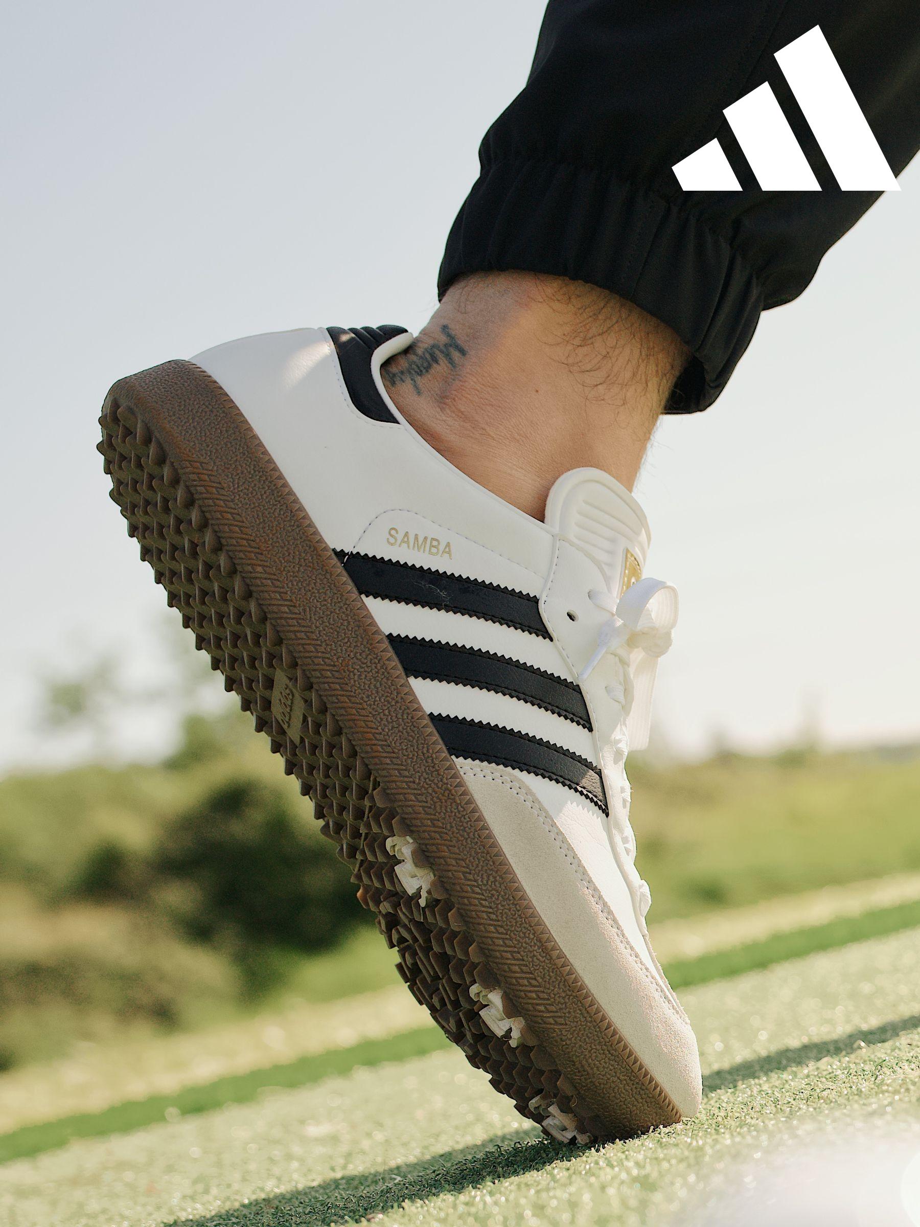 White trainers with black stripe cheap
