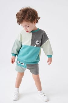  (M78447) | €21 - €26 Blauwgroen monster - Jersey sweatshirt met kleurvlakken en shorts (3 mnd-7 jr)