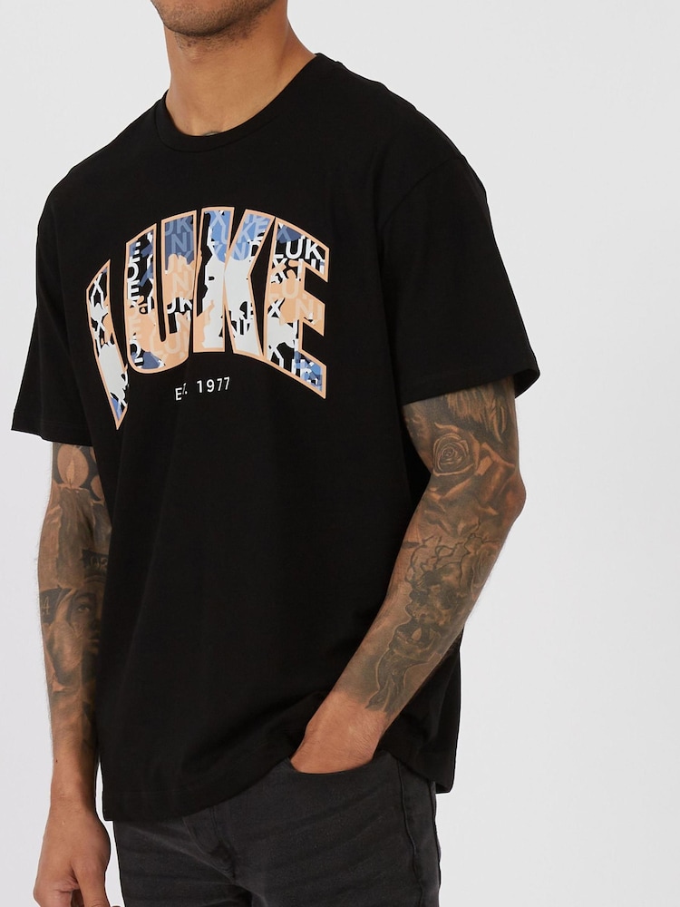 Luke 1977 X Nathan Dawe LAGANAS 100% Cotton Black T-Shirts - Image 1 of 7 Luke 1977 X Nathan Dawe LAGANAS 100% Cotton Black T-Shirts - Image 1 of 7