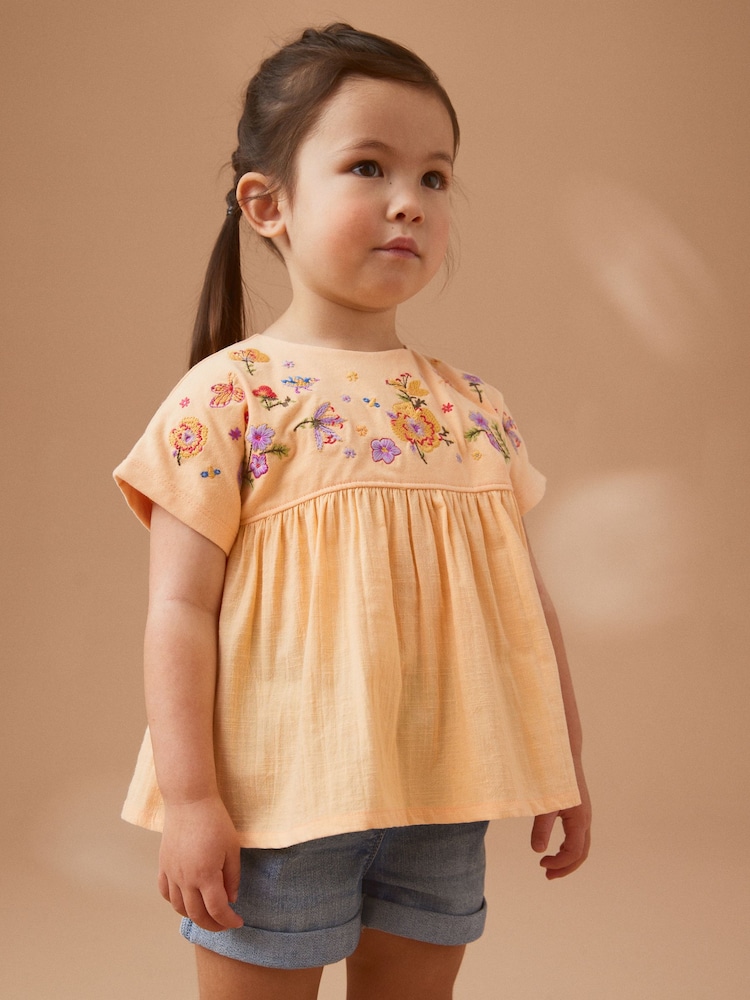 Pfirsich/Blumenstickerei - Kurzärmelige Bluse (3 Monate – 7 Jahre) - Bild 1 von 7 Pfirsich/Blumenstickerei - Kurzärmelige Bluse (3 Monate – 7 Jahre) - Bild 1 von 7