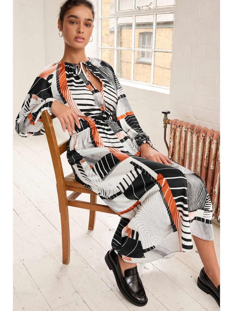 Monochrom/Orange mit abstraktem Print - Langärmliges Midikleid mit Bindeschleife - Bild 2 von 6
