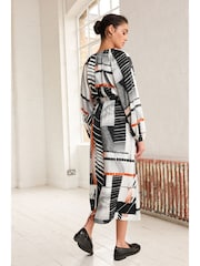 Monochrom/Orange mit abstraktem Print - Langärmliges Midikleid mit Bindeschleife - Bild 3 von 6