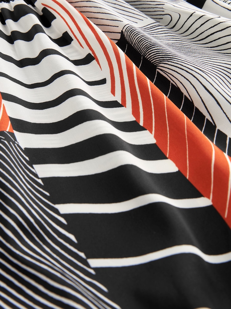 Monochrom/Orange mit abstraktem Print - Langärmliges Midikleid mit Bindeschleife - Bild 6 von 6