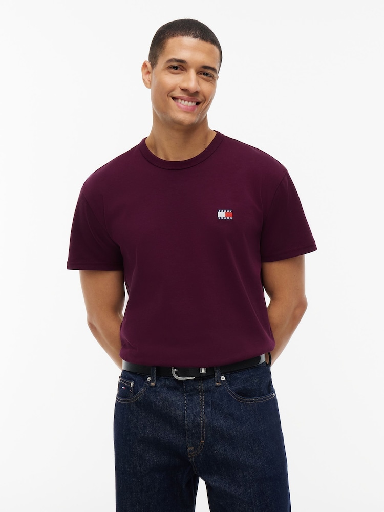 أحمر - تي شيرت بشارة بلون واحد بياقة بحافة مستديرة من Tommy Jeans - صورة 1 من 5 أحمر - تي شيرت بشارة بلون واحد بياقة بحافة مستديرة من Tommy Jeans - صورة 1 من 5