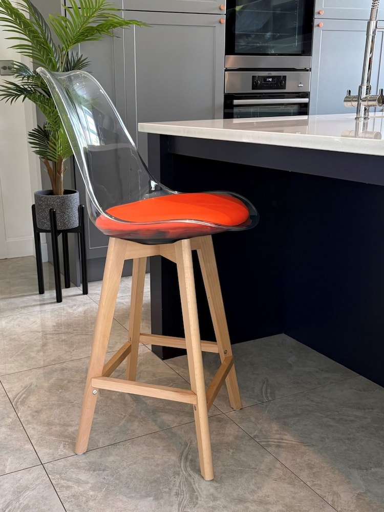 Fusion Living Orange Soho Clear Plastic Bar Stool with Light Wood Legs - Image 1 of 5 Fusion Living Orange Soho Clear Plastic Bar Stool with Light Wood Legs - Image 1 of 5