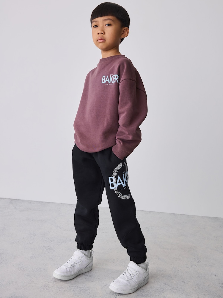 Baker by Ted Baker Black/Purple 2 Piece Oversized Graphic Sweatshirt and Joggers Set - Image 1 of 15 Baker by Ted Baker Black/Purple 2 Piece Oversized Graphic Sweatshirt and Joggers Set - Image 1 of 15