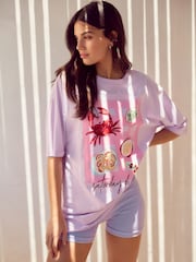 Lilac Purple  Coastal Dinner Front Graphic Relaxed Fit Short Sleeve Seam Detail Skater Style 100% Cotton T-Shirt - Image 1 of 7