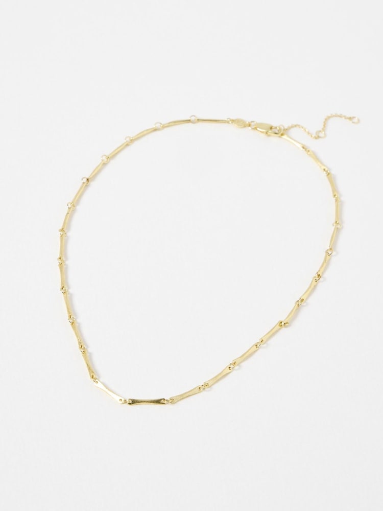 Oliver Bonas Gold Tone Eleanor Textured Bar Collar Necklace - Image 1 of 3 Oliver Bonas Gold Tone Eleanor Textured Bar Collar Necklace - Image 1 of 3