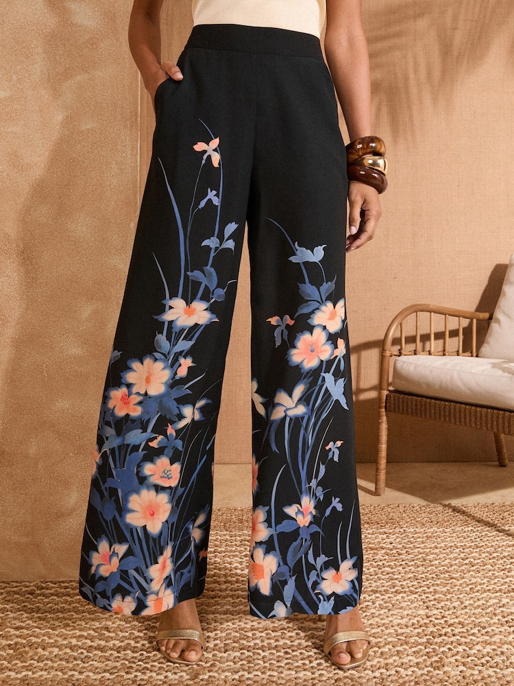 Love & Roses Black Floral Wide Leg Printed Trousers - Image 1 of 5 Love & Roses Black Floral Wide Leg Printed Trousers - Image 1 of 5