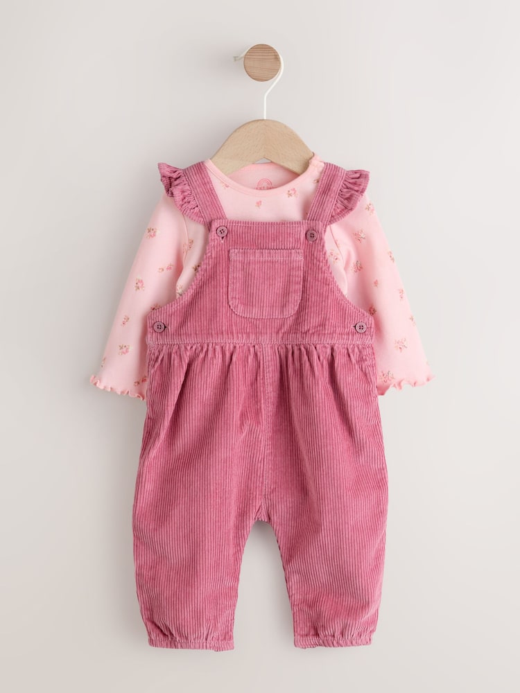 Rosa Blümchen - Baby Print Long Sleeve Bodysuit and Cord Dungarees 2 Piece Set (0mths-2yrs) - Bild 1 von 8 Rosa Blümchen - Baby Print Long Sleeve Bodysuit and Cord Dungarees 2 Piece Set (0mths-2yrs) - Bild 1 von 8