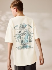 Crema con estampado trasero de palmera - Camiseta holgada de manga corta con estampado gráfico (3-16 años) - Imagen 1 de 7