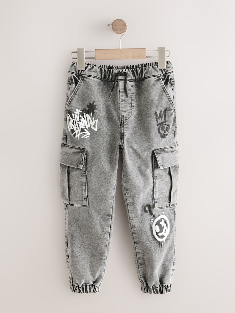 Grey Graffiti Cargo Jeans With Elasticated Waist (3-16yrs) - Image 1 of 4 Grey Graffiti Cargo Jeans With Elasticated Waist (3-16yrs) - Image 1 of 4