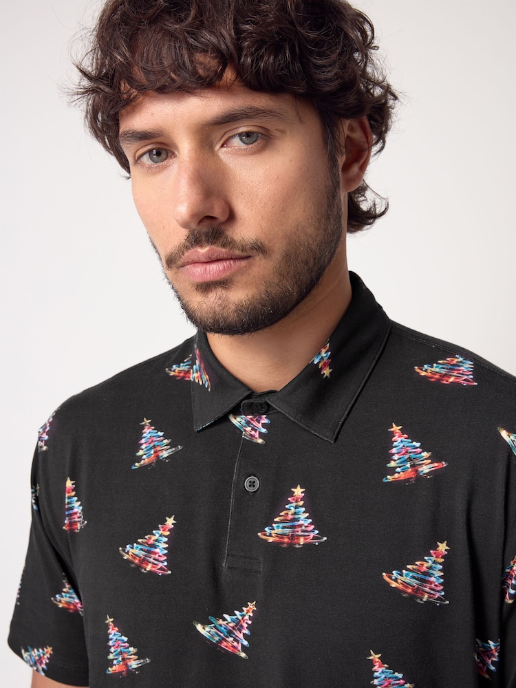 Schwarz/Neon mit Baummotiv - Polo-Shirt in weihnachtlichem Print - Bild 1 von 8 Schwarz/Neon mit Baummotiv - Polo-Shirt in weihnachtlichem Print - Bild 1 von 8