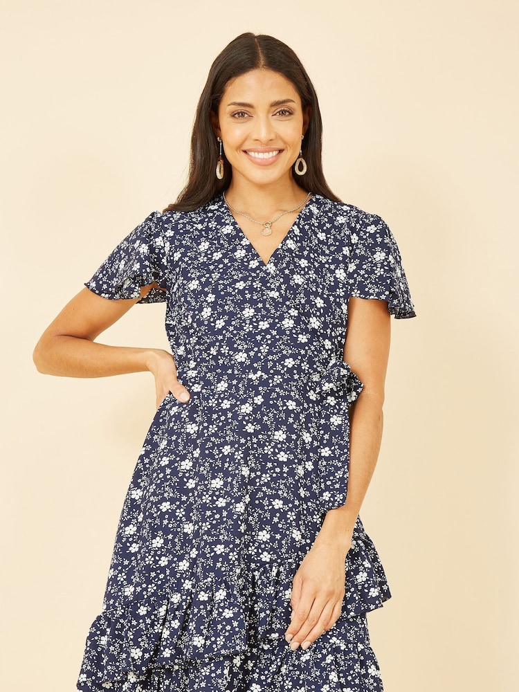 Mela Blue Ditsy Floral Wrap Frill Dress - Image 1 of 4 Mela Blue Ditsy Floral Wrap Frill Dress - Image 1 of 4