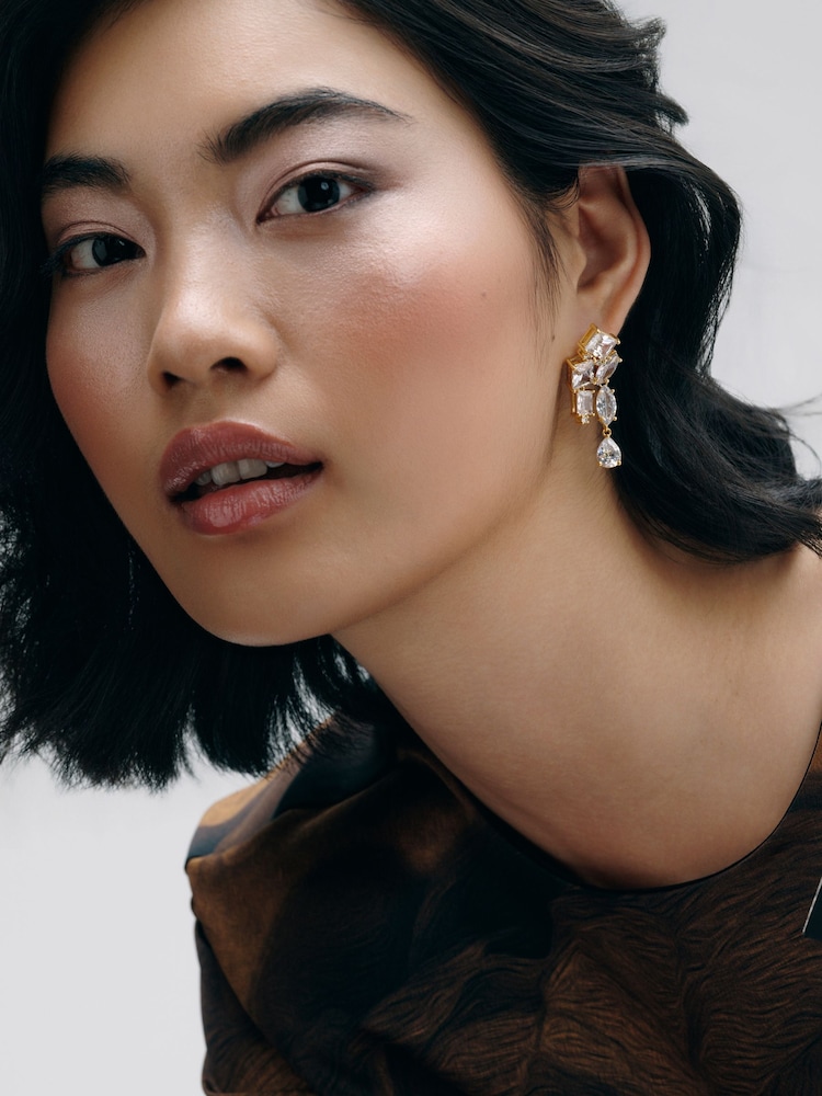 CERENE Luma Clear Gold Tone Statement Crystal Drop Earrings - Image 1 of 6 CERENE Luma Clear Gold Tone Statement Crystal Drop Earrings - Image 1 of 6