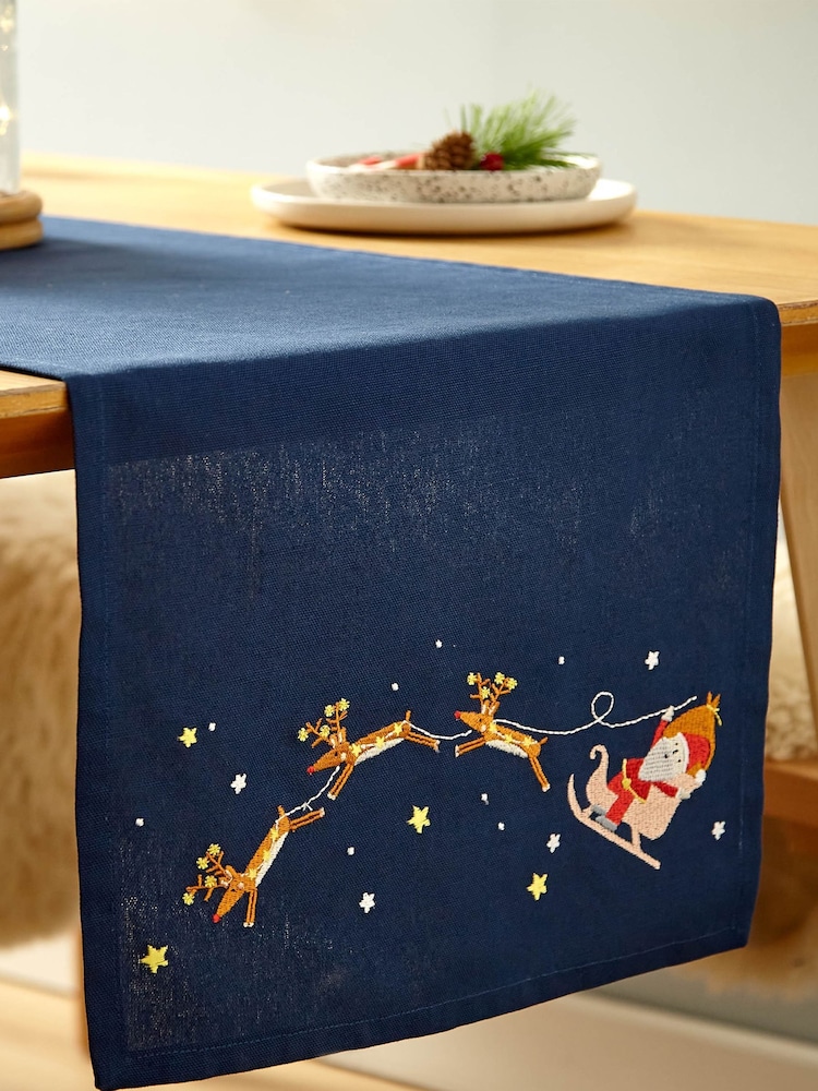 Catherine Lansfield Blue Santas Christmas Wonderland Wipeable 100% Cotton Table Runner - Image 1 of 3