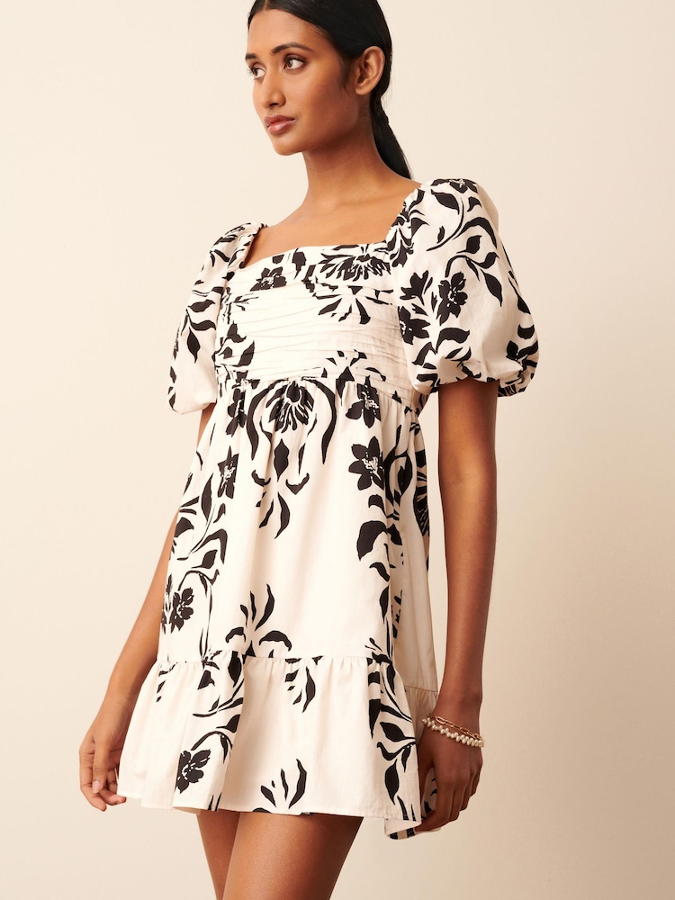 Schwarz/Weiß mit Blumenprint - Gesmoktes Minikleid mit Puffärmeln - Bild 1 von 6 Schwarz/Weiß mit Blumenprint - Gesmoktes Minikleid mit Puffärmeln - Bild 1 von 6