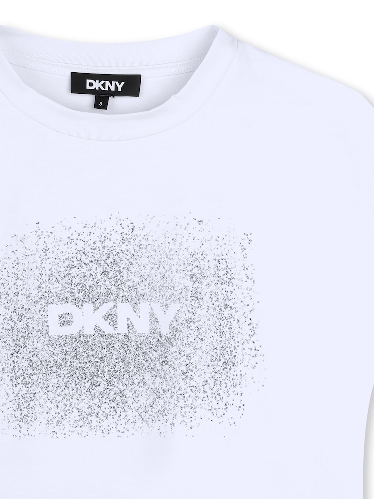 رداء علوي ضيق وقصير بلا أكمام وباللون الأبيض مزين بطبعة شعار لامع بنمط معدني من DKNY - صورة 3 من 3