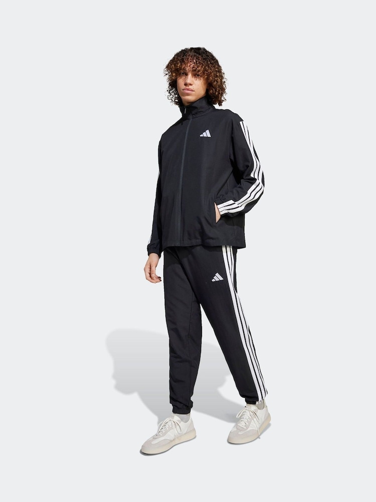أسود - بدلة رياضة أساسية منسوجة مُزيّنة بـ 3 خطوط من adidas Sportswear - صورة 1 من 8 أسود - بدلة رياضة أساسية منسوجة مُزيّنة بـ 3 خطوط من adidas Sportswear - صورة 1 من 8