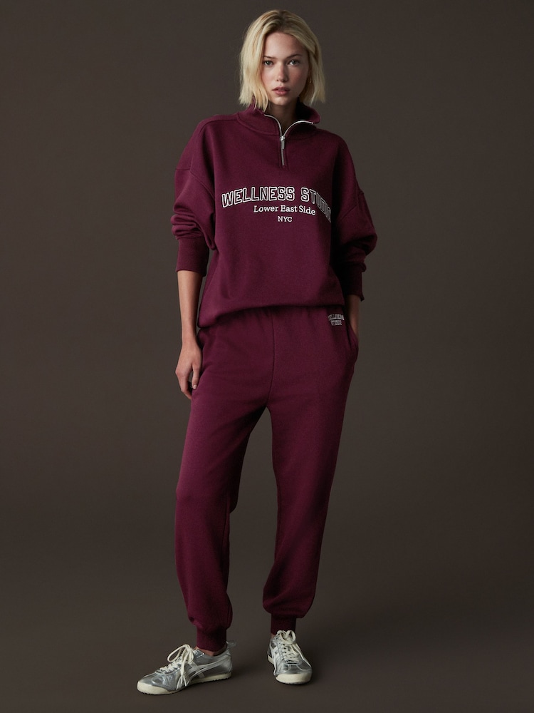 Burgunderrot - Entspannt geschnittene Jogginghosen mit Bündchen und Wellness-Slogan-Grafik - Bild 1 von 7 Burgunderrot - Entspannt geschnittene Jogginghosen mit Bündchen und Wellness-Slogan-Grafik - Bild 1 von 7
