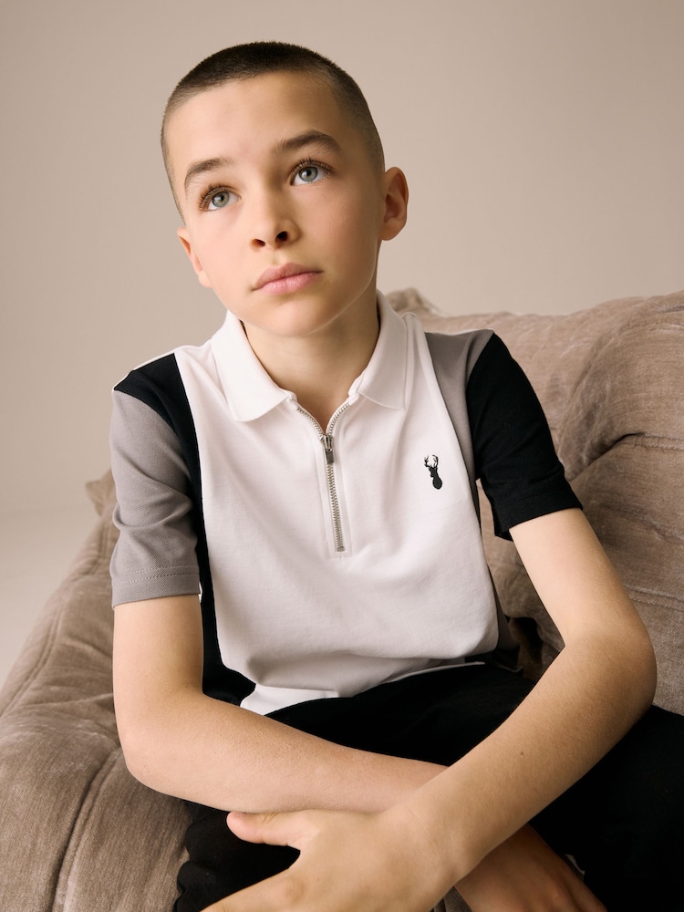 Weiß und Schwarz - Kurzarm-Polo-Shirt aus 100 % Baumwolle mit Viertelreißverschluss im Colourblock-Design (3–16 J.) - Bild 2 von 8