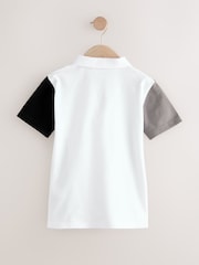 Weiß und Schwarz - Kurzarm-Polo-Shirt aus 100 % Baumwolle mit Viertelreißverschluss im Colourblock-Design (3–16 J.) - Bild 6 von 8