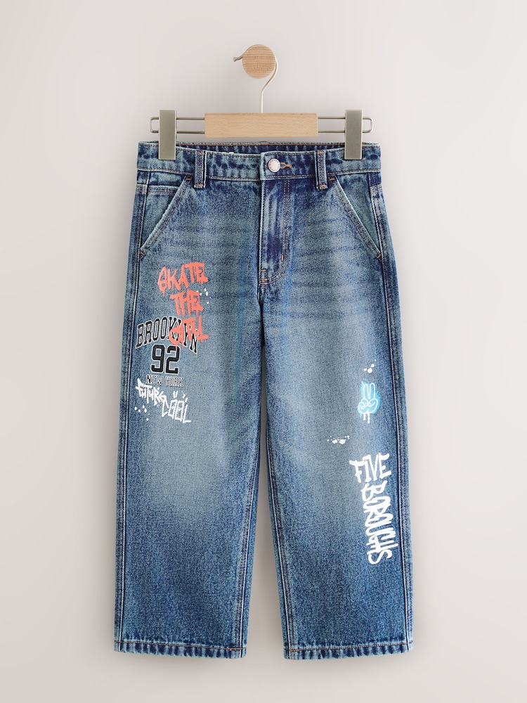 Varsity All Over Print Mid Blue Denim Wide Fit Authentic Jeans (3-16yrs) - Image 1 of 4 Varsity All Over Print Mid Blue Denim Wide Fit Authentic Jeans (3-16yrs) - Image 1 of 4