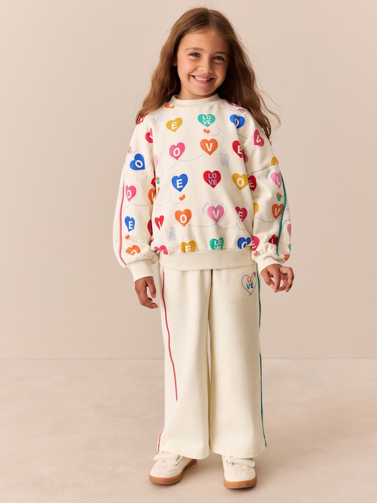 Rainbow Love Print - حزمة من 2 قطعة تتألف من سترة وبنطلونات رياضية من Little Bird - صورة 1 من 13 Rainbow Love Print - حزمة من 2 قطعة تتألف من سترة وبنطلونات رياضية من Little Bird - صورة 1 من 13