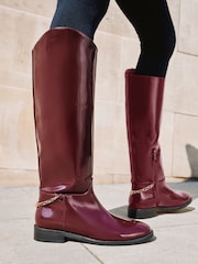 Lipsy Burgundy Red Glossy Patent Knee High Low Block Heel Riding Boots with Gold Stirrup Chain Detail - Image 1 of 6