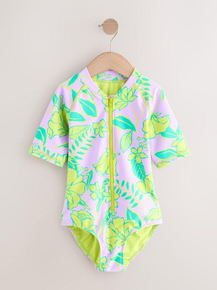 أرجواني فاتح - تصميم استوائي - Short Sleeved Sunsafe Swimsuit (3mths-16yrs) - صورة 1 من 4 أرجواني فاتح - تصميم استوائي - Short Sleeved Sunsafe Swimsuit (3mths-16yrs) - صورة 1 من 4