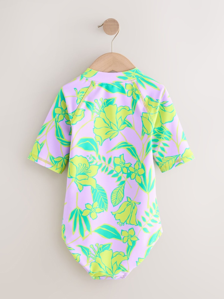 أرجواني فاتح - تصميم استوائي - Short Sleeved Sunsafe Swimsuit (3mths-16yrs) - صورة 2 من 4 أرجواني فاتح - تصميم استوائي - Short Sleeved Sunsafe Swimsuit (3mths-16yrs) - صورة 2 من 4