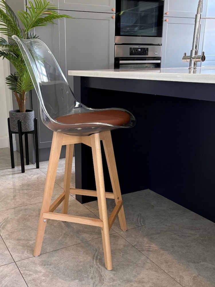 Fusion Living Chocolate Soho Clear Plastic Bar Stool with Light Wood Legs - Image 1 of 5 Fusion Living Chocolate Soho Clear Plastic Bar Stool with Light Wood Legs - Image 1 of 5