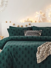 Conjunto de funda de almohada y funda de edredón de algodón 100 % en color verde pino con diseño navideño de arboles en relieve de Furn - Imagen 1 de 5