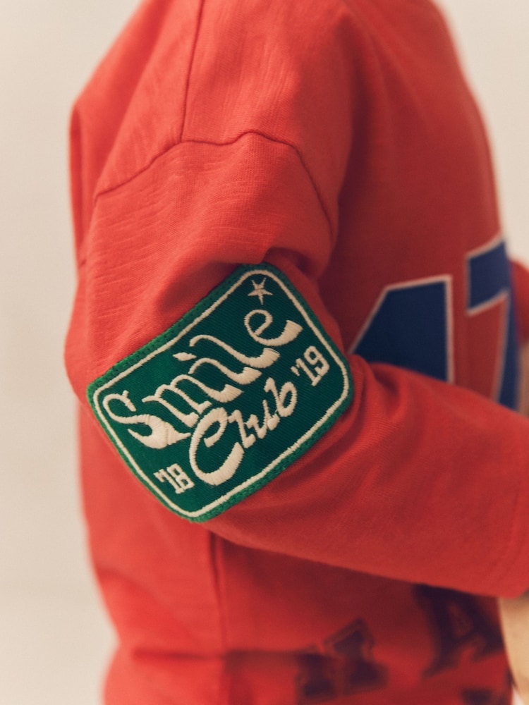 شارات ولون أحمر - تيشرت رياضي بكُم طويل مزيّن بطبعة فريق Varsity قطن 100% (3 أشهر - 7 سنوات) - صورة 2 من 5