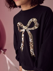 Black/Gold Sequin Bow Long Sleeve Wrap Back 100% Cotton Top (3-16yrs) - Image 4 of 4