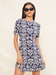 Friends Like These Navy Ikat Petite Print Short Sleeve Ruffle Hem Jersey Mini Dress - Image 1 of 4