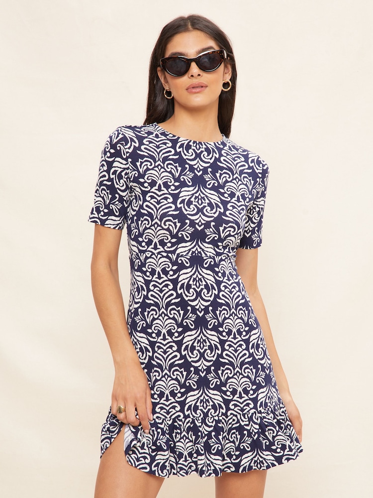 Friends Like These Navy Ikat Petite Print Short Sleeve Ruffle Hem Jersey Mini Dress - Image 1 of 4 Friends Like These Navy Ikat Petite Print Short Sleeve Ruffle Hem Jersey Mini Dress - Image 1 of 4