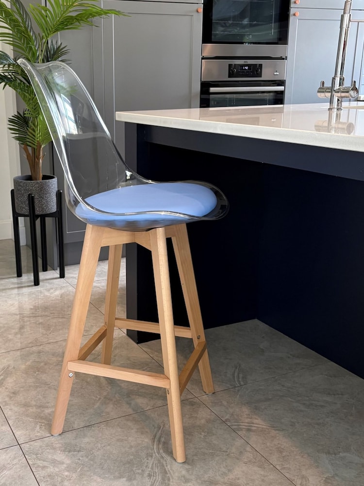 Fusion Living Blue Soho Clear Plastic Bar Stool with Light Wood Legs - Image 1 of 5 Fusion Living Blue Soho Clear Plastic Bar Stool with Light Wood Legs - Image 1 of 5