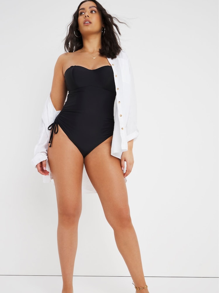 Figleaves Rene Black Underwired Tummy Control Adjustable Leg Bandeau Swimsuit - Image 1 of 4