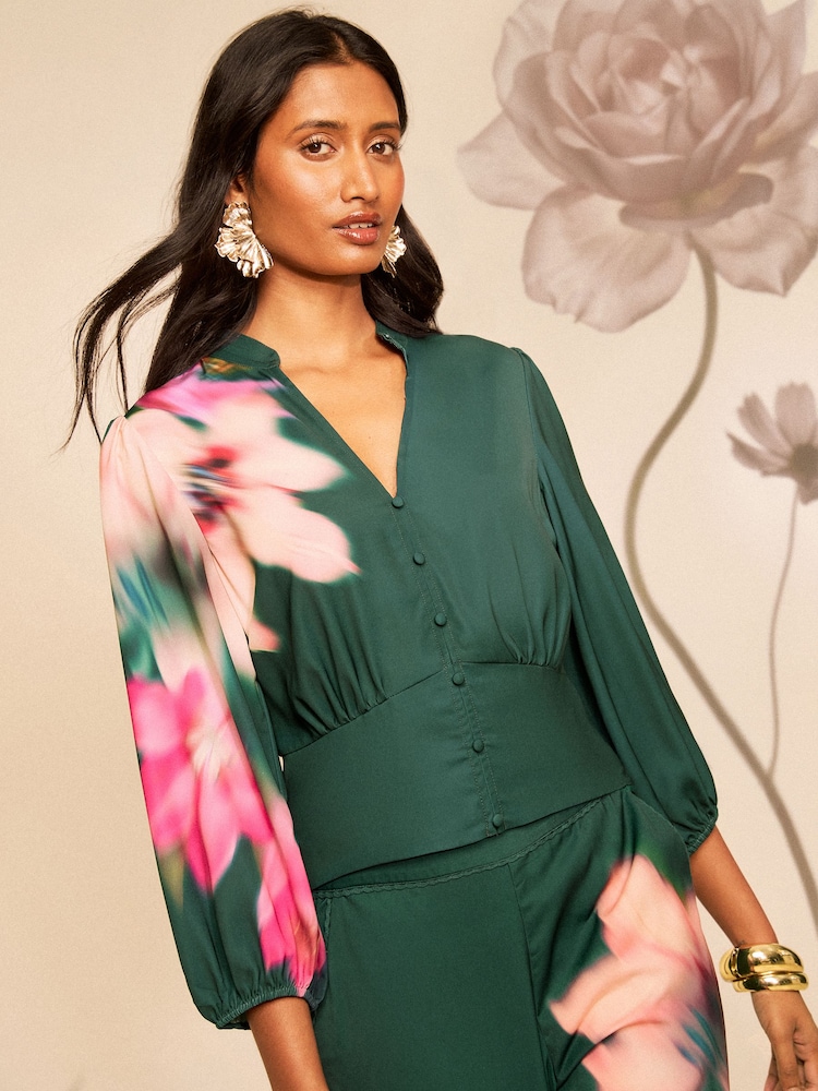 Love & Roses X RHS Green Blurred Floral Puff Sleeve V-Neck Blouse - Image 1 of 5 Love & Roses X RHS Green Blurred Floral Puff Sleeve V-Neck Blouse - Image 1 of 5
