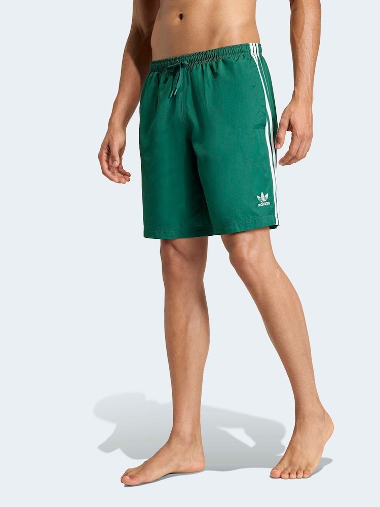 adidas Green Adicolor 3 Stripes Swim Shorts 8 Inch - Image 1 of 6 adidas Green Adicolor 3 Stripes Swim Shorts 8 Inch - Image 1 of 6