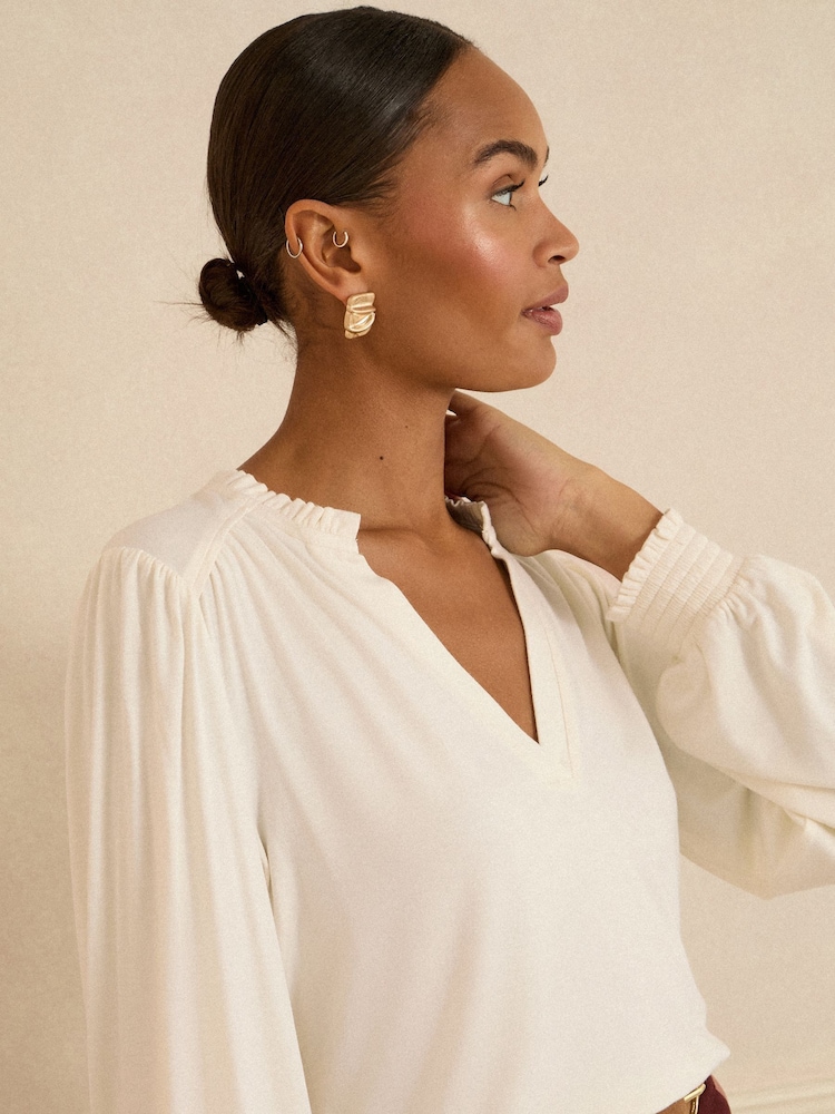 أبيض عاجي - توب جيرسيه بأكمام طويلة وياقة V مع كشكش من Love & Roses - Image 2 of 4 أبيض عاجي - توب جيرسيه بأكمام طويلة وياقة V مع كشكش من Love & Roses - Image 2 of 4