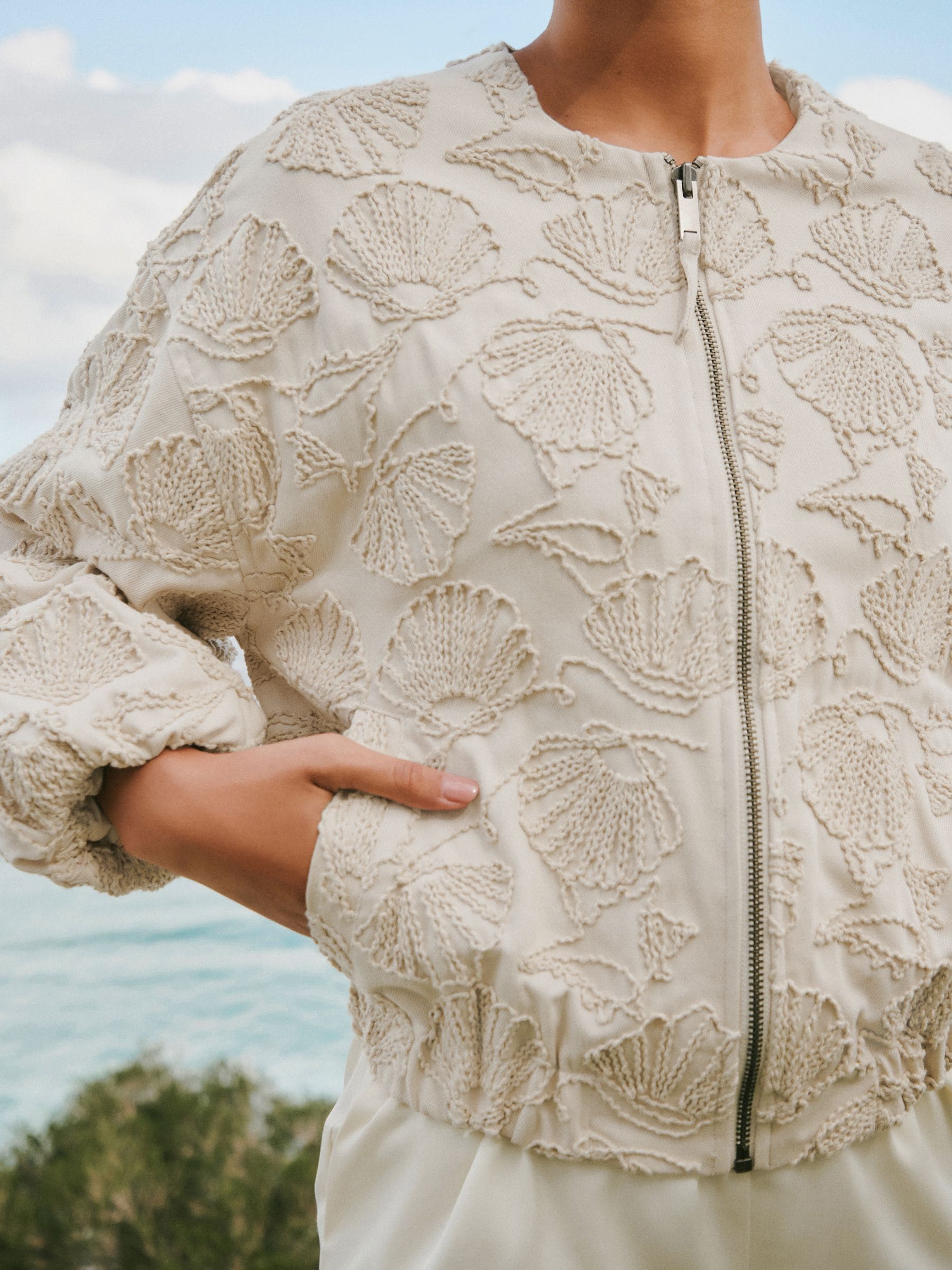 Next：日本 ベージュ - Seashell 刺繍入りコットンジップアップ