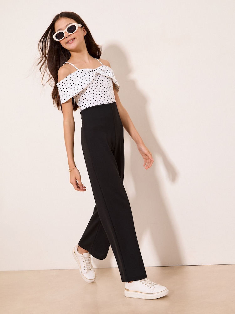 Lipsy Black/White Polka Dot Bow Bardot Jumpsuit (7-16yrs) - Image 1 of 5 Lipsy Black/White Polka Dot Bow Bardot Jumpsuit (7-16yrs) - Image 1 of 5