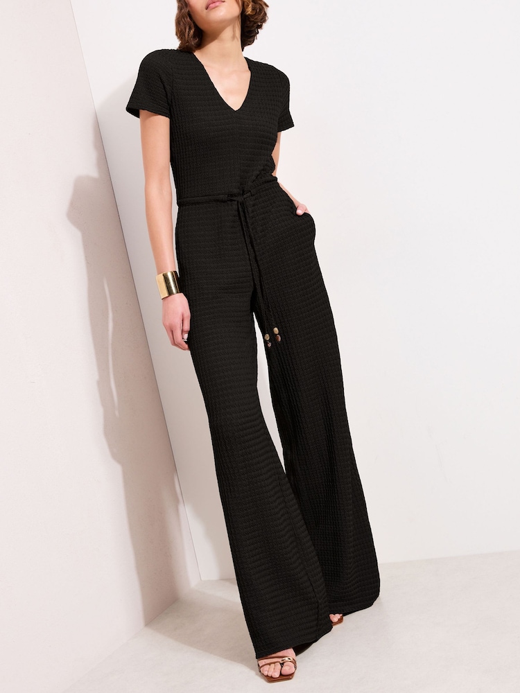 Friends Like These Black Petite Short Sleeve Jersey Textured Jumpsuit - Image 1 of 4 Friends Like These Black Petite Short Sleeve Jersey Textured Jumpsuit - Image 1 of 4