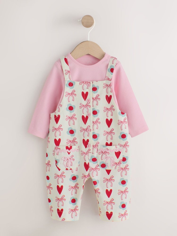 Ecru/Pink Bow And Heart Baby Long Sleeve Bodysuit And Woven Dungarees Set 2 Piece (0mths-2yrs) - Image 1 of 7 Ecru/Pink Bow And Heart Baby Long Sleeve Bodysuit And Woven Dungarees Set 2 Piece (0mths-2yrs) - Image 1 of 7